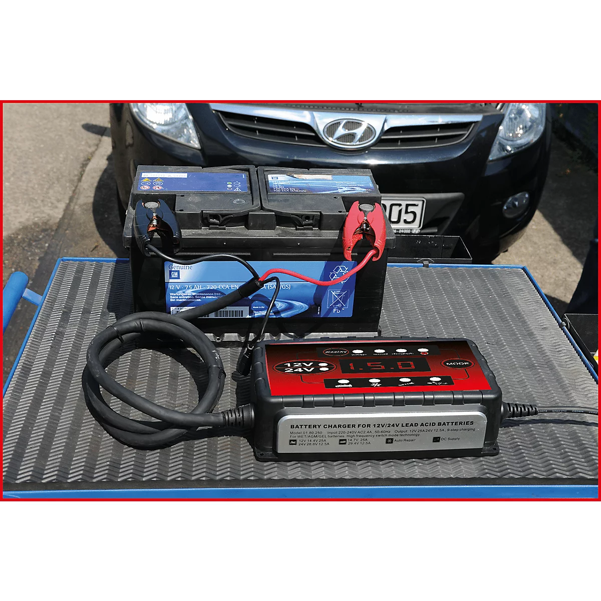 Batterieladegerät lädt Autobatterie. Rote und schwarze Kabel verbunden, Ladegerät mit Anzeige.